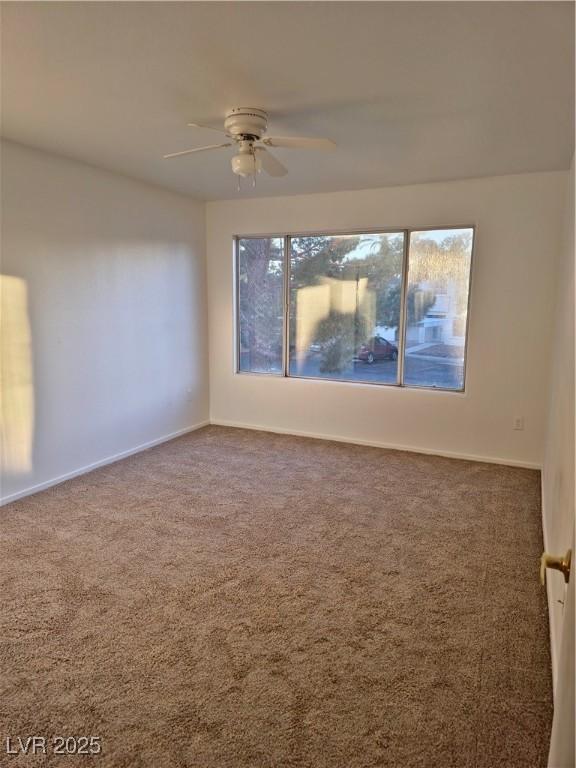 spare room featuring carpet flooring, a wealth of natural light, and ceiling fan