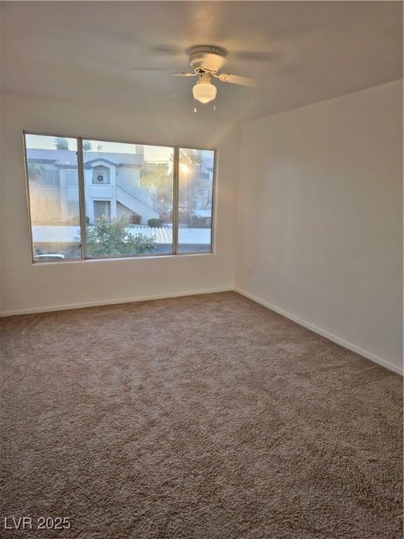 empty room with ceiling fan and carpet floors