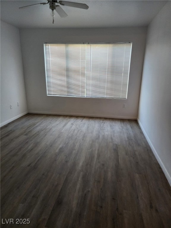 spare room featuring dark wood-type flooring and ceiling fan