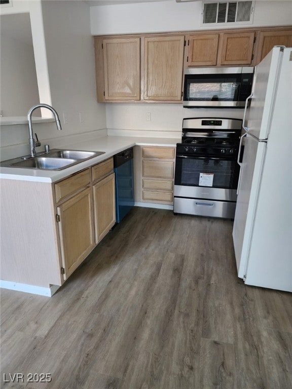 kitchen with appliances with stainless steel finishes, sink, dark wood-type flooring, and light brown cabinetry