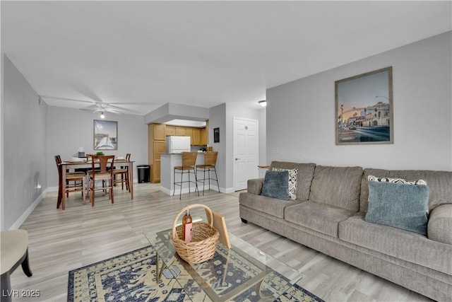 living room featuring ceiling fan and light hardwood / wood-style floors