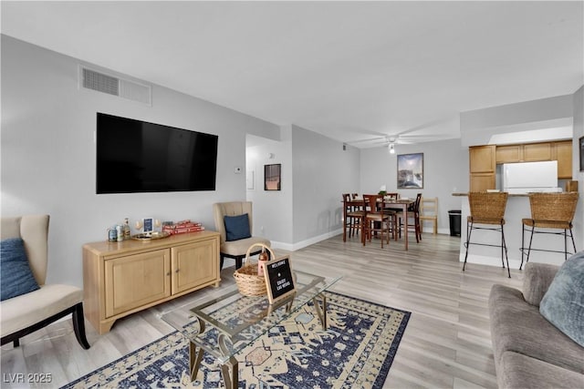 living room featuring ceiling fan and light hardwood / wood-style flooring