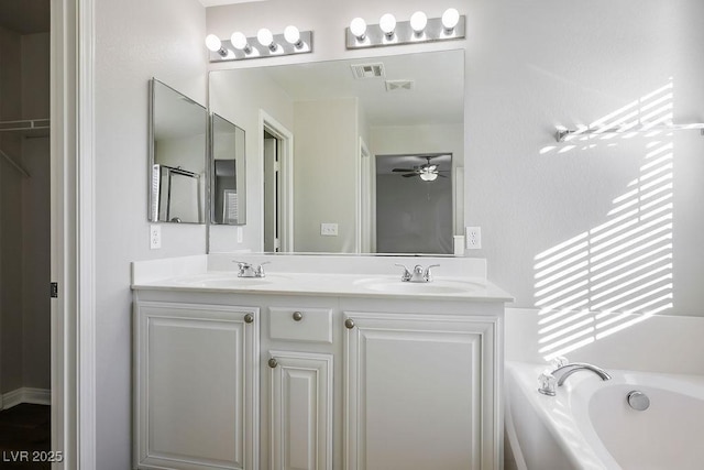 bathroom featuring vanity, a tub, and ceiling fan