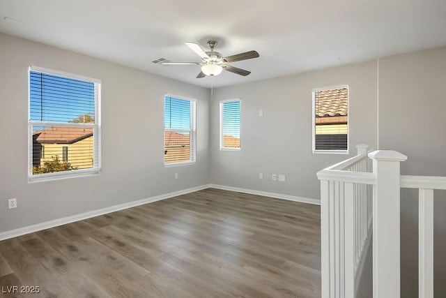 spare room with dark wood-type flooring and ceiling fan