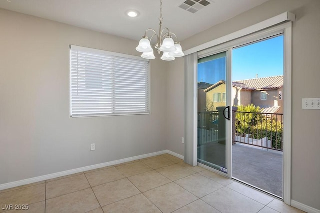 unfurnished room featuring an inviting chandelier and light tile patterned floors