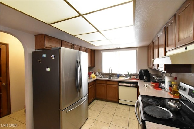 kitchen featuring stainless steel appliances, sink, and light tile patterned floors