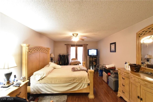 bedroom with dark wood-type flooring, ceiling fan, and a textured ceiling