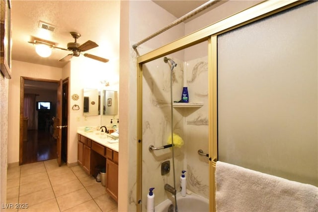 bathroom featuring tile patterned flooring, enclosed tub / shower combo, vanity, and ceiling fan