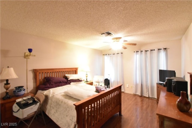 bedroom with multiple windows, a textured ceiling, ceiling fan, and hardwood / wood-style flooring