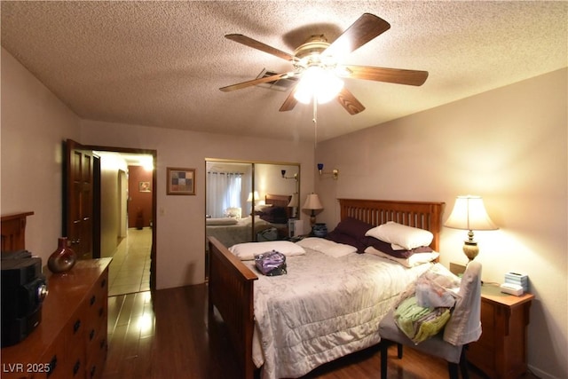 bedroom featuring hardwood / wood-style floors, a textured ceiling, and ceiling fan