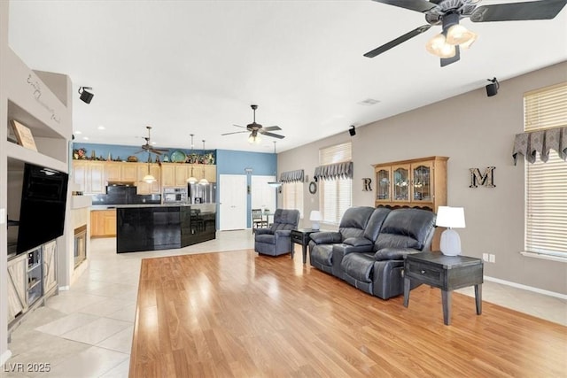 living room featuring light tile patterned floors and ceiling fan