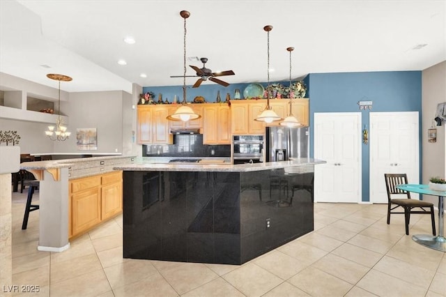 kitchen with pendant lighting, light brown cabinets, stainless steel appliances, and a kitchen island