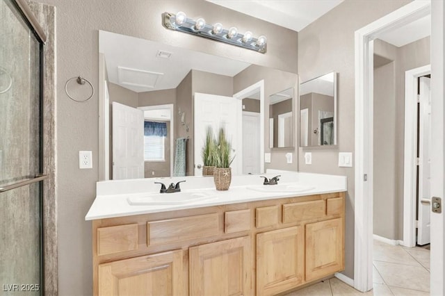 bathroom featuring a shower with door, vanity, and tile patterned floors