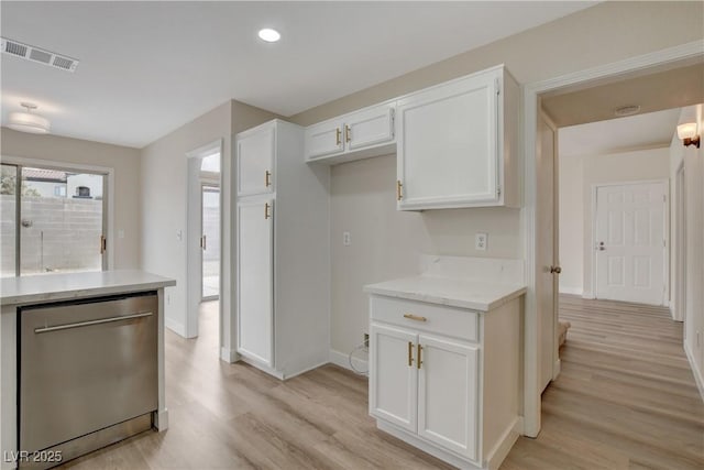 kitchen with light wood-type flooring, white cabinetry, dishwasher, and light stone counters