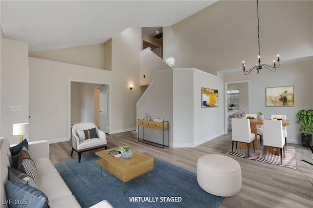 living room featuring hardwood / wood-style flooring, high vaulted ceiling, and an inviting chandelier