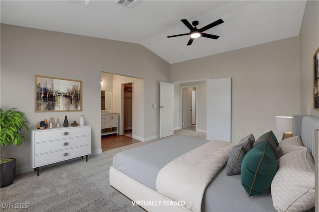 bedroom featuring ceiling fan, vaulted ceiling, light carpet, and connected bathroom