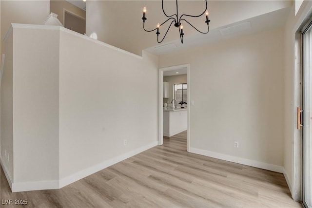 unfurnished dining area featuring light hardwood / wood-style floors and an inviting chandelier