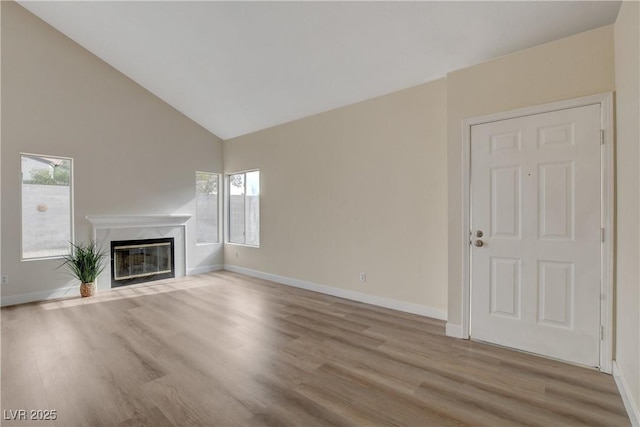 unfurnished living room with a fireplace, high vaulted ceiling, and light hardwood / wood-style floors