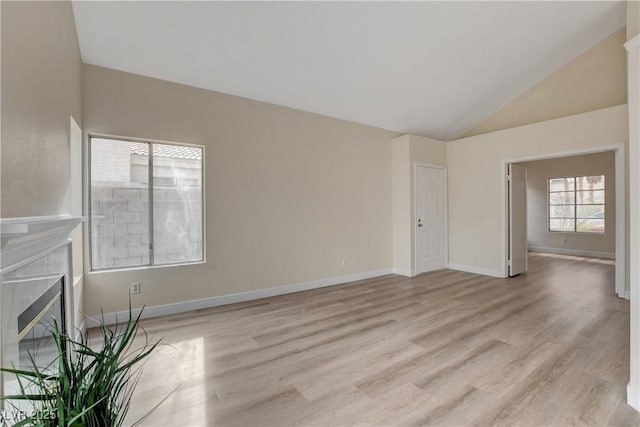 unfurnished living room with a fireplace, lofted ceiling, and light hardwood / wood-style flooring