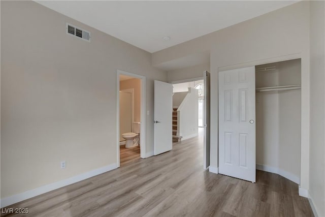 unfurnished bedroom with light wood-type flooring and a closet