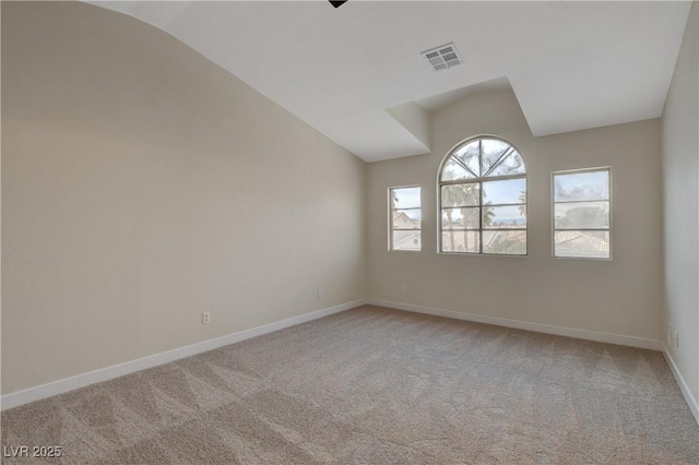 carpeted empty room with lofted ceiling