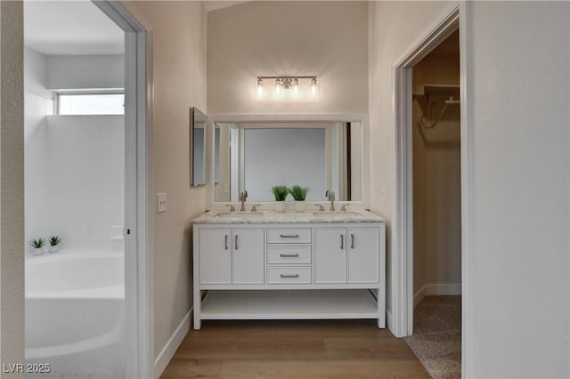 bathroom with wood-type flooring, vanity, and a bathing tub