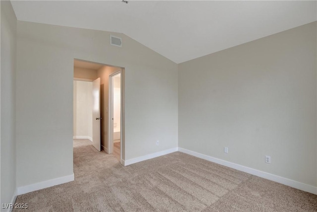 carpeted empty room with vaulted ceiling