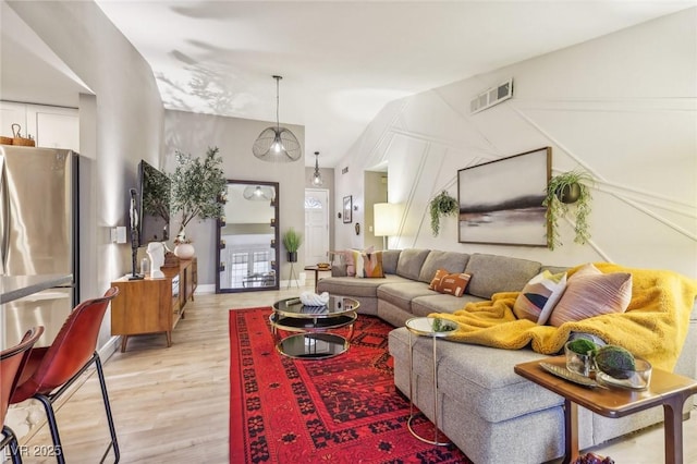 living room featuring vaulted ceiling and light wood-type flooring