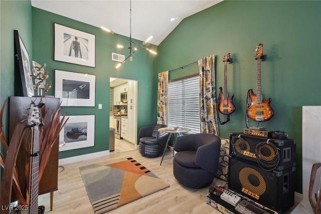 living area with high vaulted ceiling and light wood-type flooring