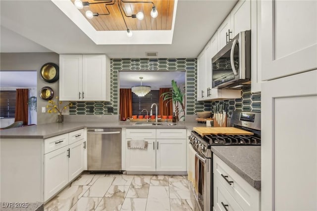 kitchen with white cabinetry, appliances with stainless steel finishes, and sink