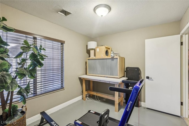 exercise room featuring a wealth of natural light and a textured ceiling