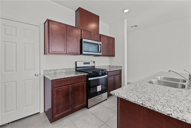 kitchen featuring sink, stainless steel appliances, light stone countertops, and light tile patterned flooring