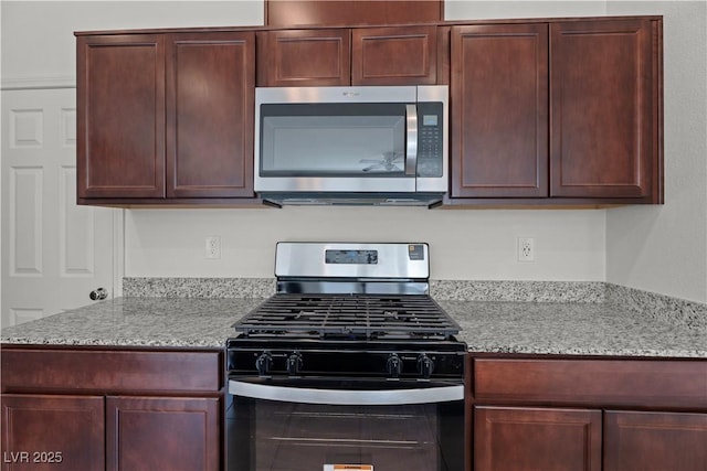 kitchen featuring light stone countertops and range with gas stovetop