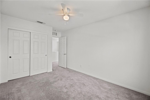 unfurnished bedroom with light carpet, ceiling fan, and a closet