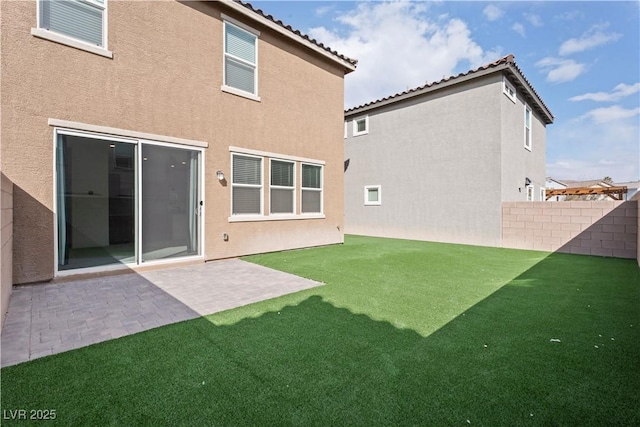 rear view of property with a yard and a patio