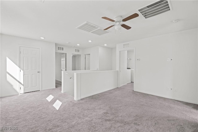 carpeted spare room featuring ceiling fan