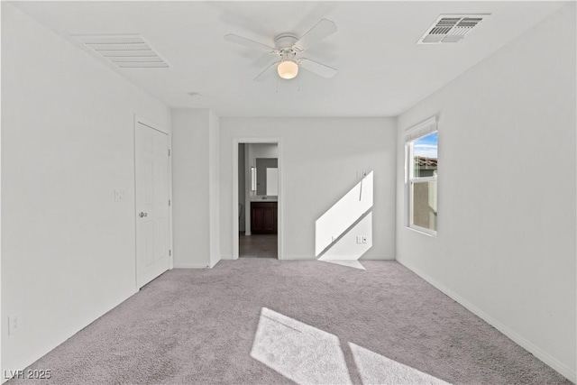 empty room with light colored carpet and ceiling fan