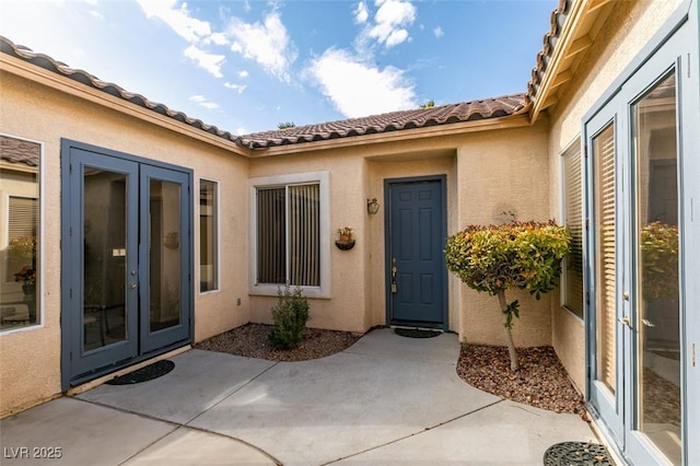 view of exterior entry featuring a patio and french doors