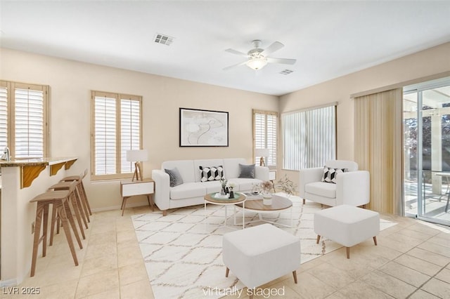 living room with plenty of natural light, light tile patterned floors, and ceiling fan