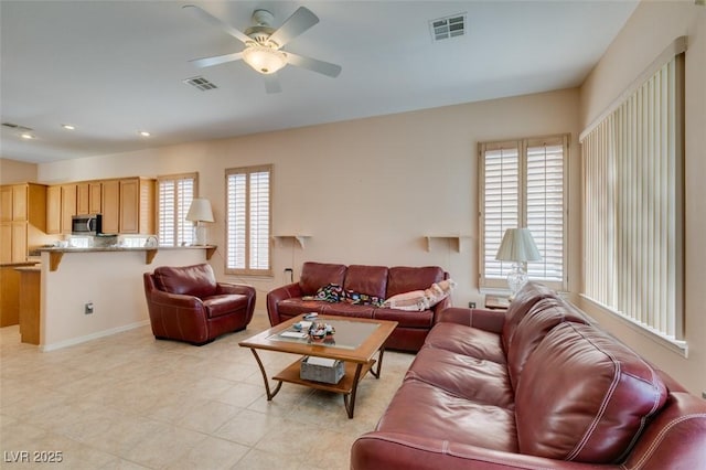 living room with ceiling fan, plenty of natural light, and light tile patterned floors