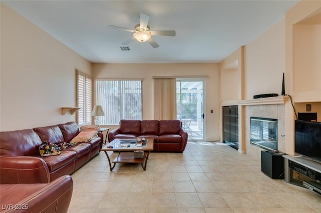 living room with ceiling fan, light tile patterned floors, and a fireplace