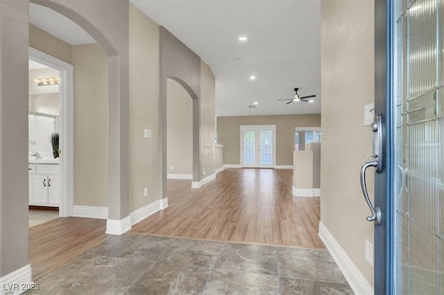 foyer entrance featuring light hardwood / wood-style flooring, ceiling fan, and french doors