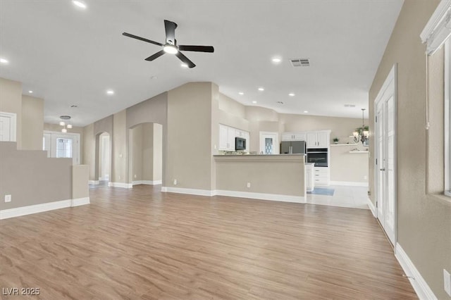 unfurnished living room featuring vaulted ceiling, ceiling fan, and light wood-type flooring