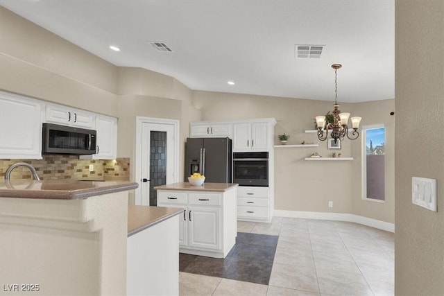 kitchen with pendant lighting, white cabinetry, stainless steel appliances, a kitchen island, and decorative backsplash