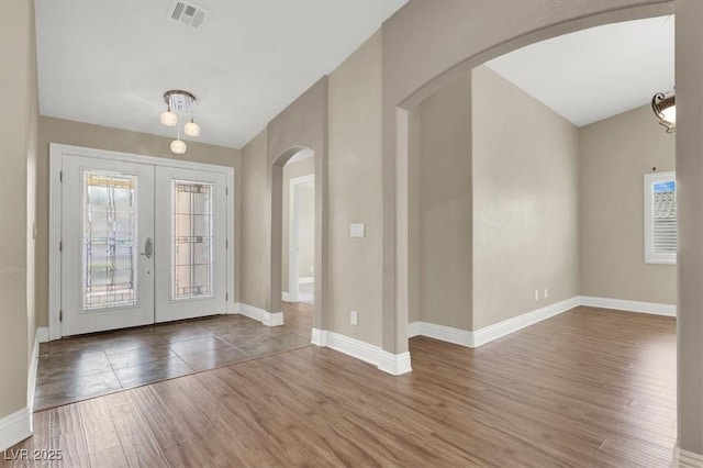 foyer featuring french doors, a healthy amount of sunlight, and hardwood / wood-style flooring