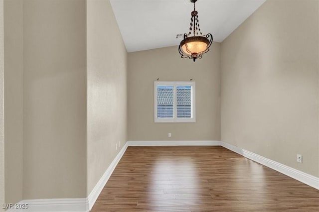 unfurnished room with hardwood / wood-style flooring and vaulted ceiling