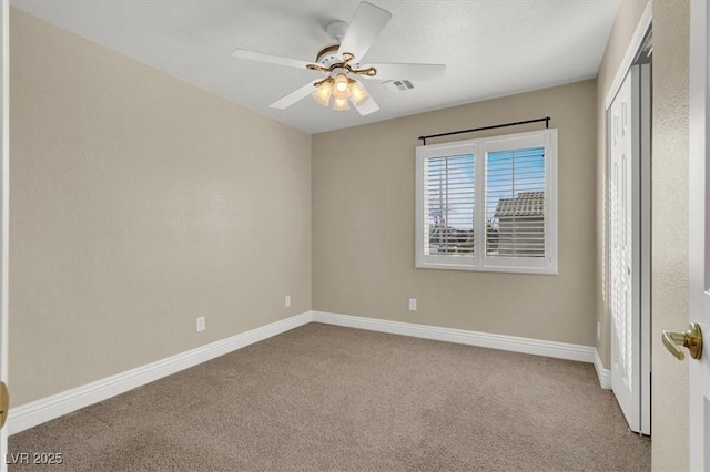 carpeted spare room with ceiling fan