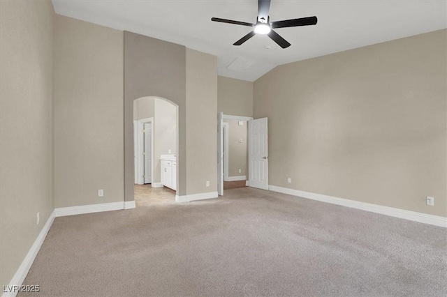 spare room featuring lofted ceiling, light carpet, and ceiling fan