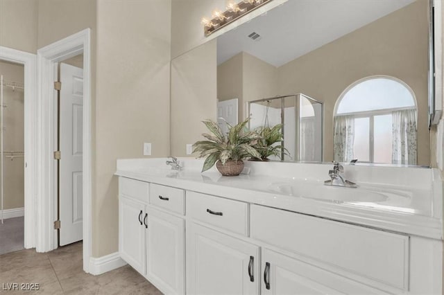 bathroom featuring tile patterned flooring, vanity, and a shower with shower door