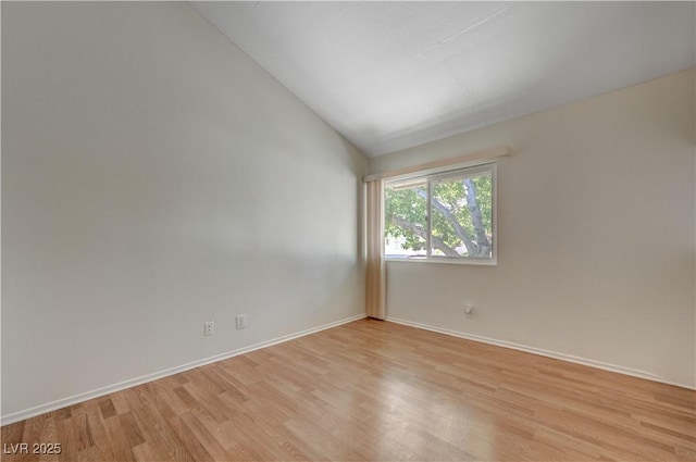 empty room featuring lofted ceiling and light hardwood / wood-style floors